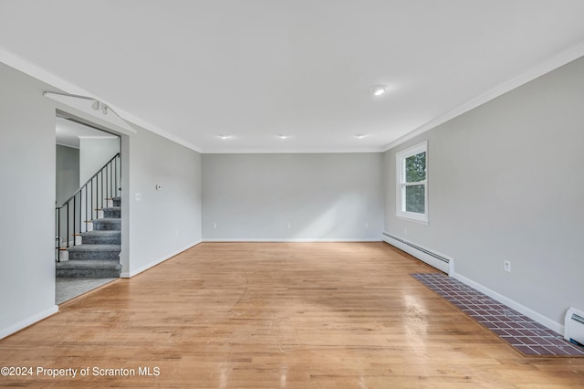 spare room featuring light hardwood / wood-style floors, crown molding, and baseboard heating