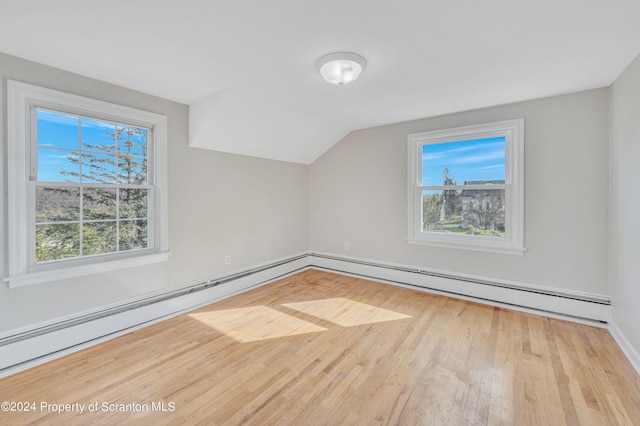 additional living space with light hardwood / wood-style flooring, baseboard heating, and lofted ceiling