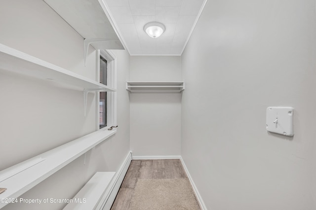 walk in closet with a baseboard radiator