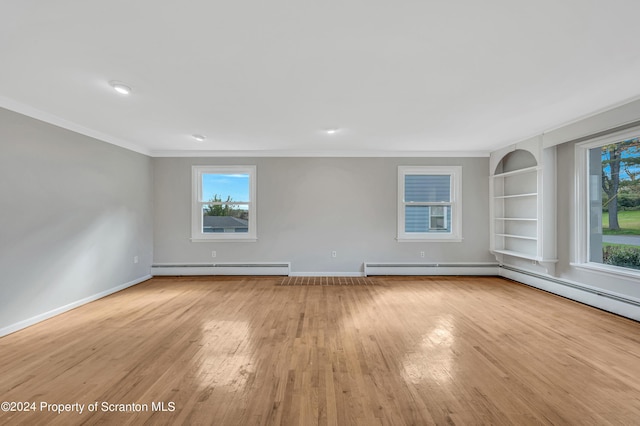 unfurnished room featuring light wood-type flooring, built in features, and a baseboard radiator