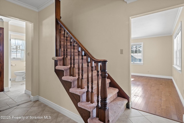 staircase with ornamental molding, tile patterned flooring, a healthy amount of sunlight, and baseboards