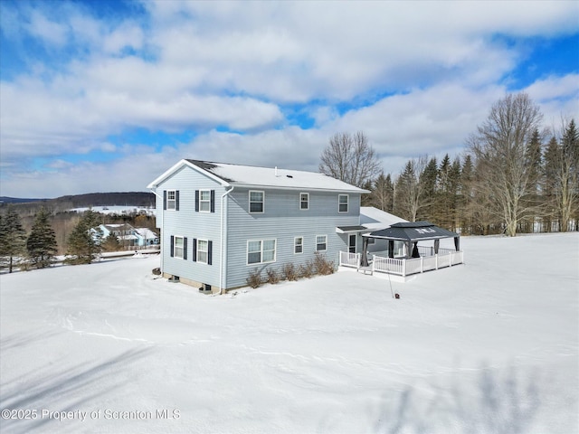 view of snow covered back of property