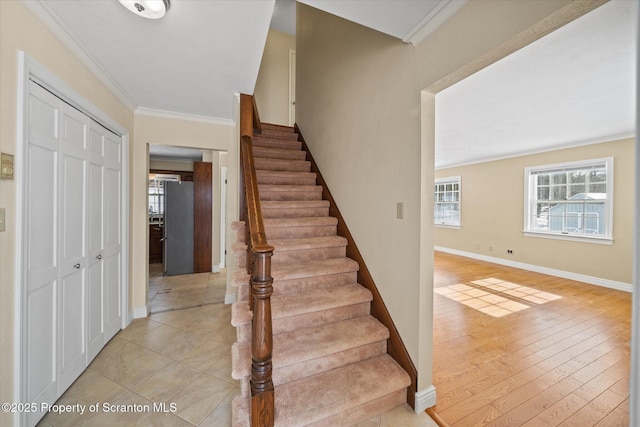 stairway with crown molding, baseboards, and wood finished floors