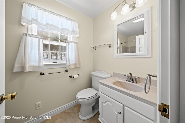 bathroom featuring baseboards, vanity, toilet, and tile patterned floors