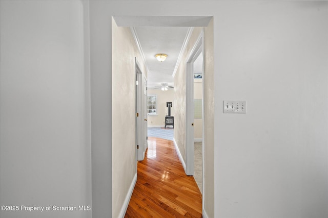 hall with baseboards and wood finished floors