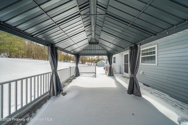 snow covered patio featuring a storage unit