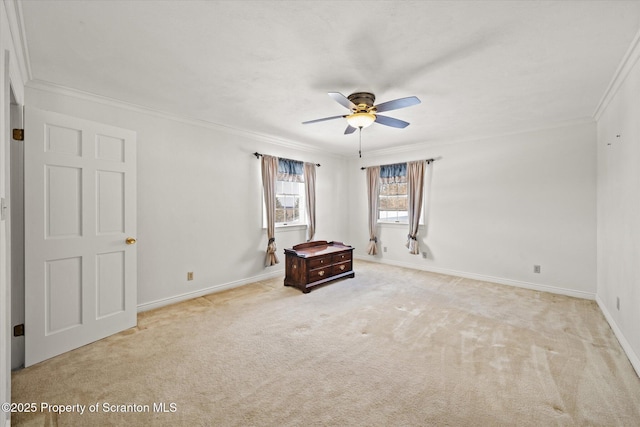 interior space with light colored carpet, crown molding, baseboards, and ceiling fan