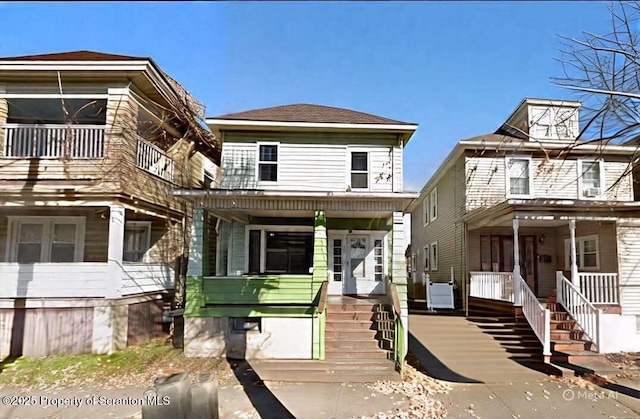 american foursquare style home featuring covered porch