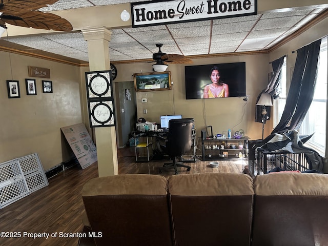 living room featuring ceiling fan, crown molding, wood finished floors, a desk, and ornate columns