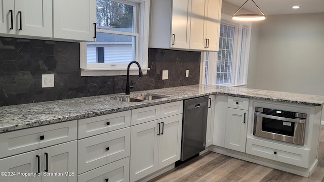 kitchen with decorative backsplash, sink, white cabinetry, and stainless steel appliances