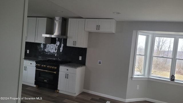 kitchen featuring white cabinetry, high end black range, dark stone counters, and wall chimney range hood