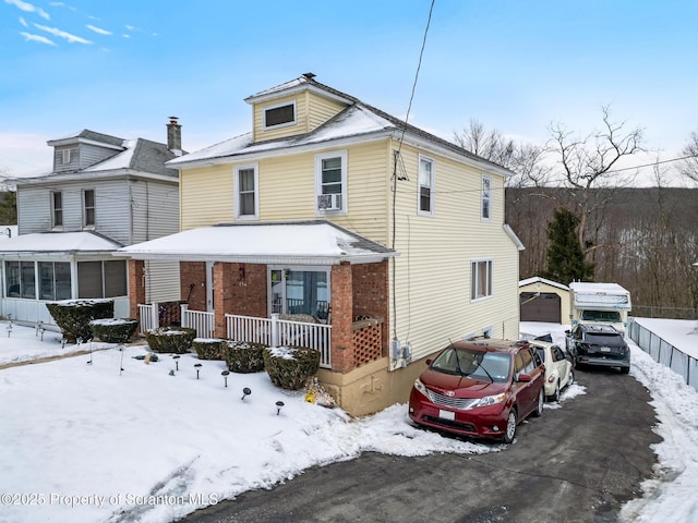 american foursquare style home featuring covered porch, driveway, and a garage