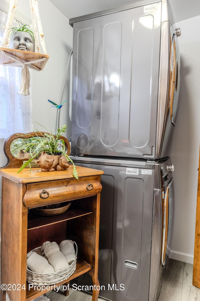 laundry area featuring hardwood / wood-style floors and stacked washer and dryer