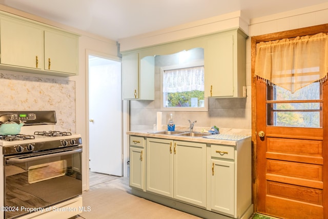 kitchen with backsplash, sink, and gas range oven