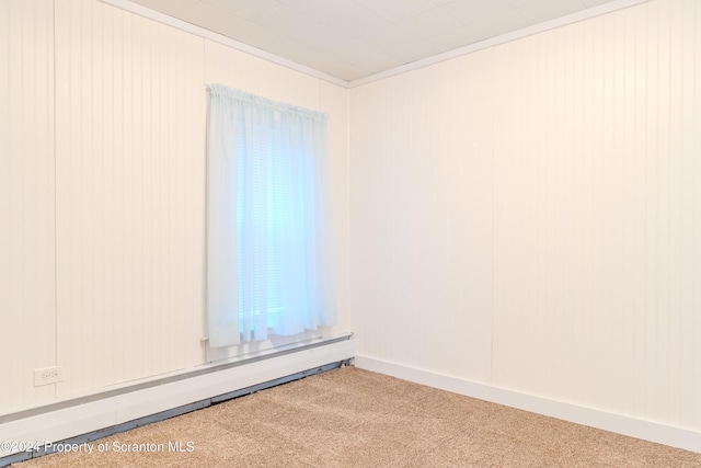 spare room with carpet, ornamental molding, and baseboard heating