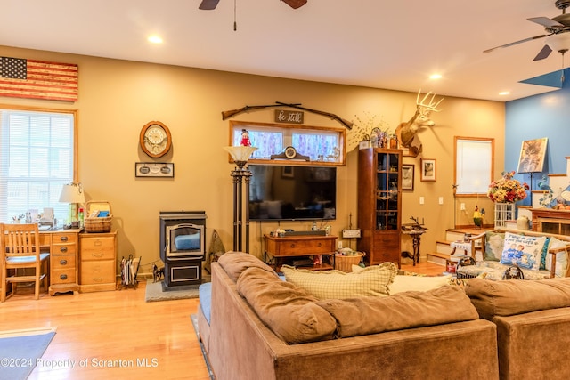 living room with a wood stove and light wood-type flooring