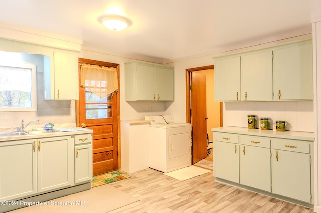 washroom featuring cabinets, light hardwood / wood-style flooring, washer and dryer, and sink