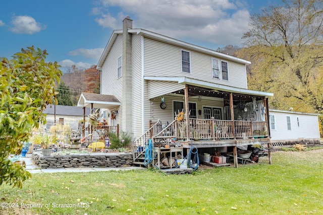 back of property featuring a sunroom and a yard