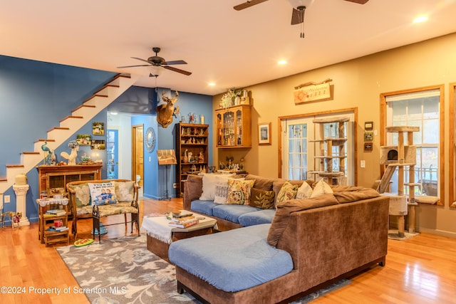 living room featuring ceiling fan and light hardwood / wood-style flooring