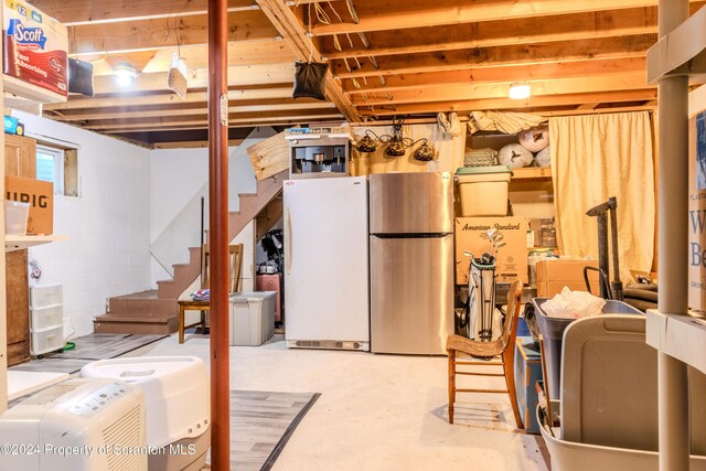 basement featuring stainless steel refrigerator