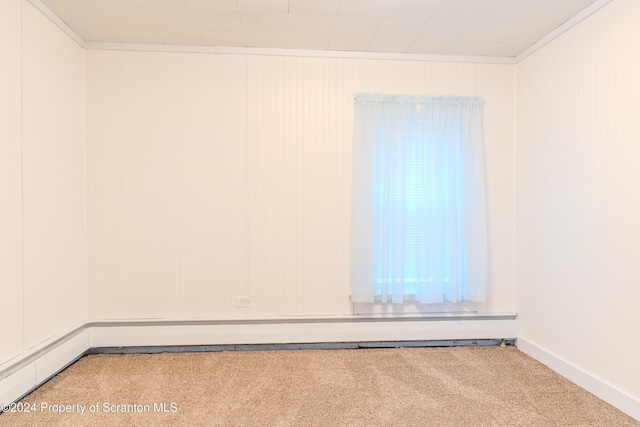 carpeted spare room featuring a baseboard radiator and ornamental molding