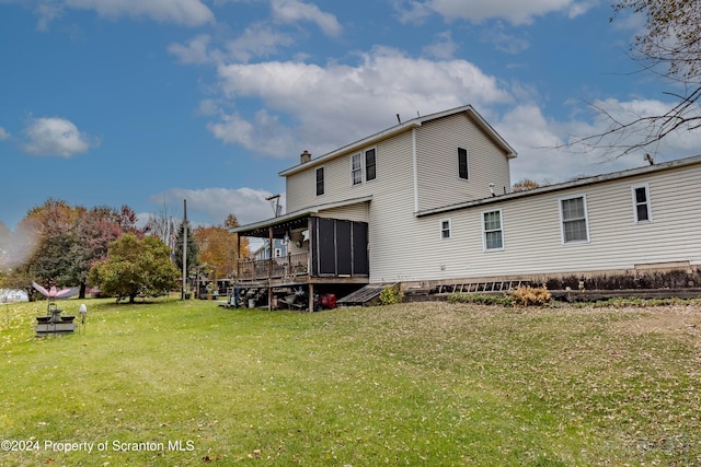 back of property with a lawn and a sunroom