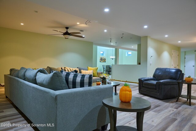 living room with ceiling fan and light wood-type flooring