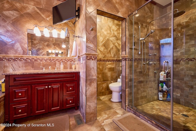 bathroom featuring vanity, an enclosed shower, tile walls, and toilet