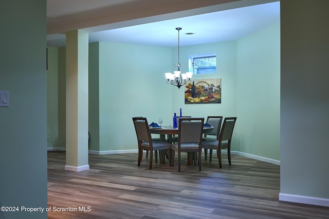 dining room featuring an inviting chandelier and dark wood-type flooring