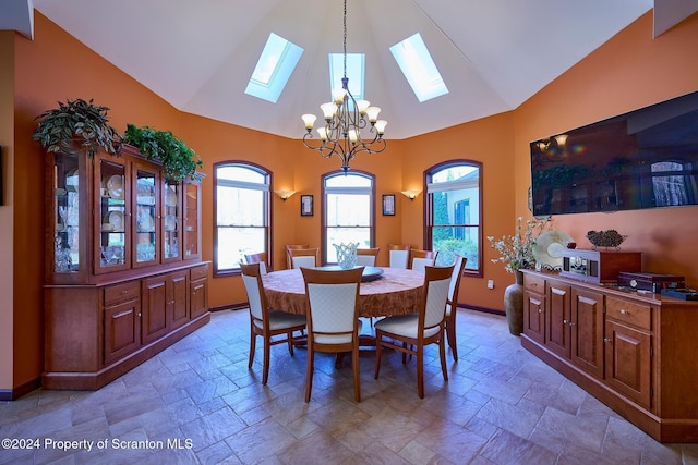 dining space with a skylight, high vaulted ceiling, and a chandelier