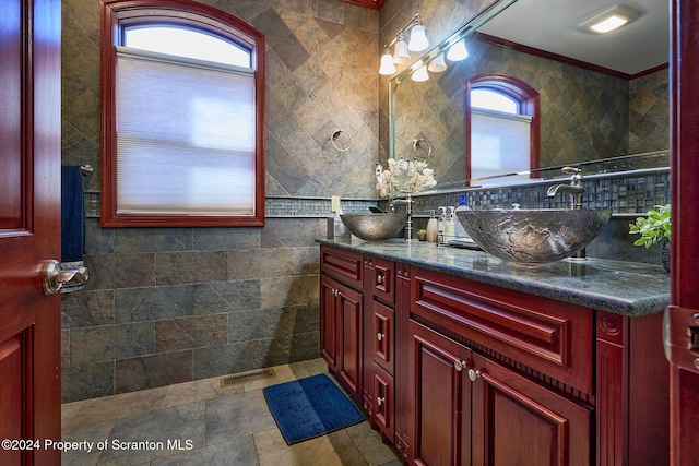 bathroom with vanity, ornamental molding, and tile walls