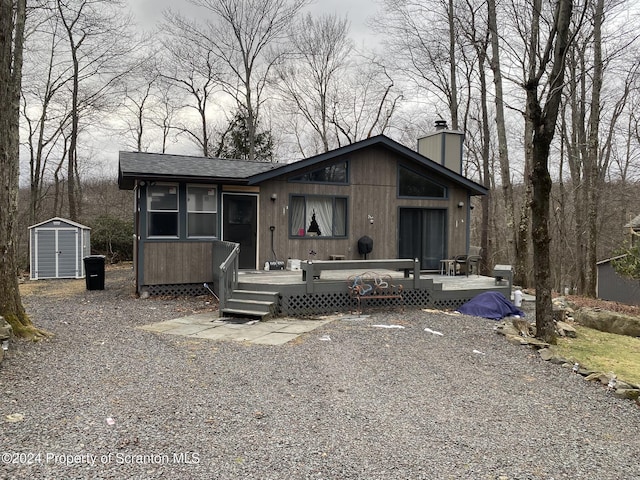 view of front facade featuring a storage unit and a wooden deck