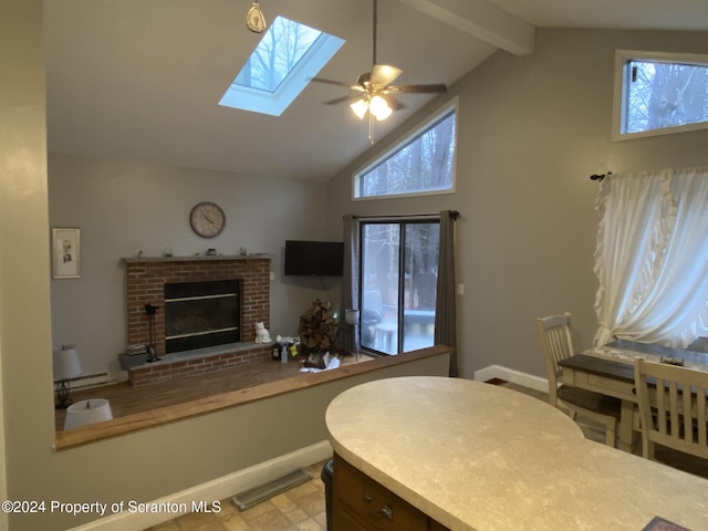 interior space with ceiling fan, a fireplace, a baseboard radiator, and lofted ceiling with skylight