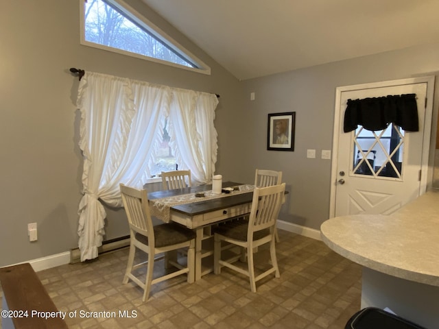 dining room featuring high vaulted ceiling and a baseboard heating unit