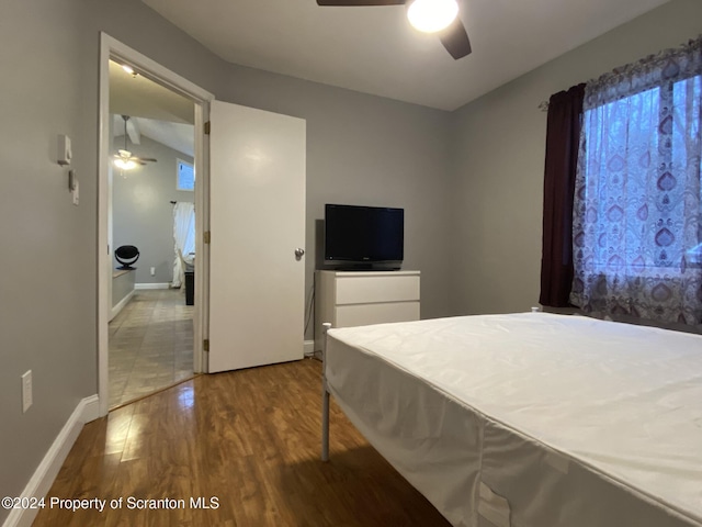 bedroom featuring hardwood / wood-style floors, ceiling fan, and lofted ceiling