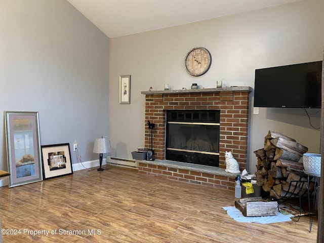 living room with a fireplace, hardwood / wood-style floors, a baseboard radiator, and vaulted ceiling