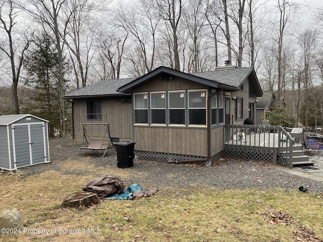 back of house featuring a shed and a wooden deck