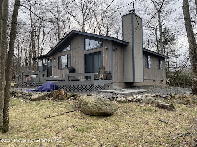 view of front facade with a wooden deck and a front lawn