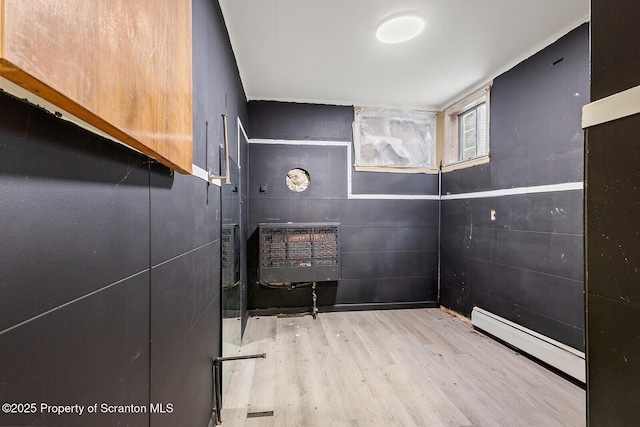 interior space with hardwood / wood-style flooring and a baseboard heating unit