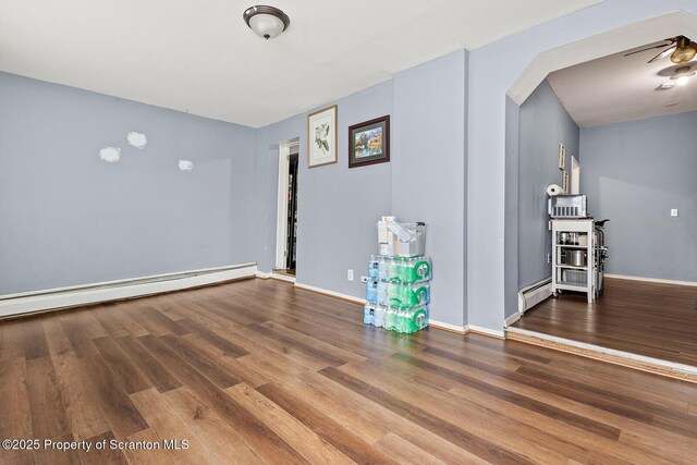 unfurnished room featuring hardwood / wood-style flooring and baseboard heating