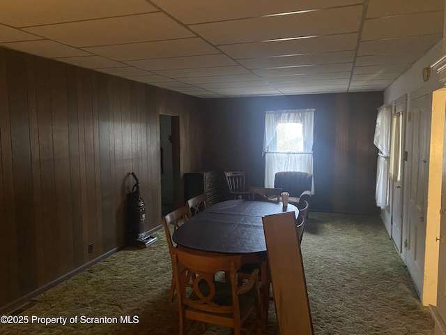 unfurnished dining area featuring carpet and wood walls