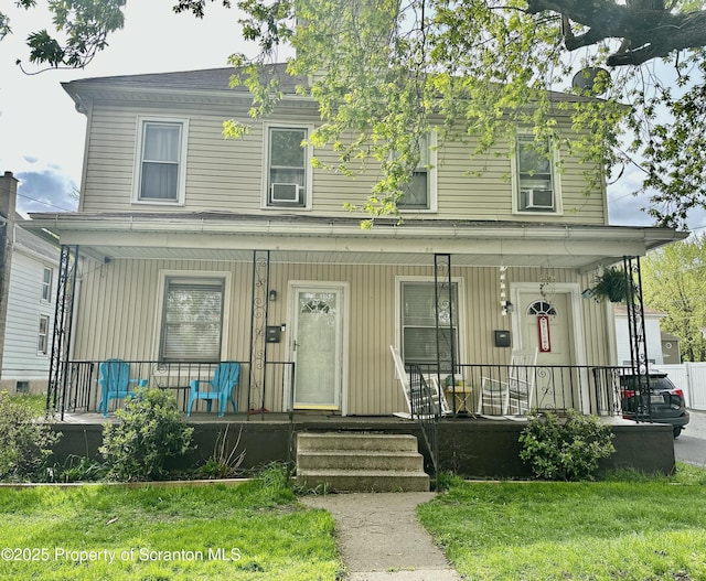 view of front facade with covered porch and a front lawn