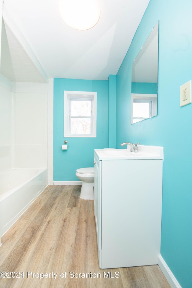 full bathroom featuring hardwood / wood-style floors, vanity, shower / bath combination, and toilet