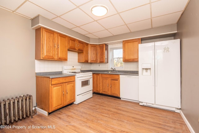 kitchen featuring a drop ceiling, white appliances, radiator, sink, and light wood-type flooring