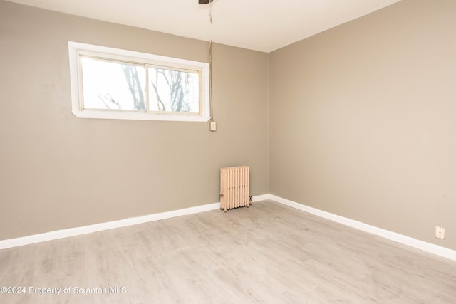 empty room featuring light hardwood / wood-style flooring and radiator