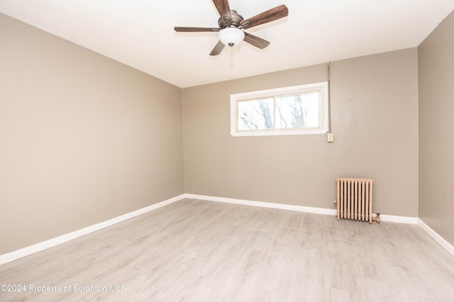 unfurnished room with light hardwood / wood-style floors, radiator, and ceiling fan