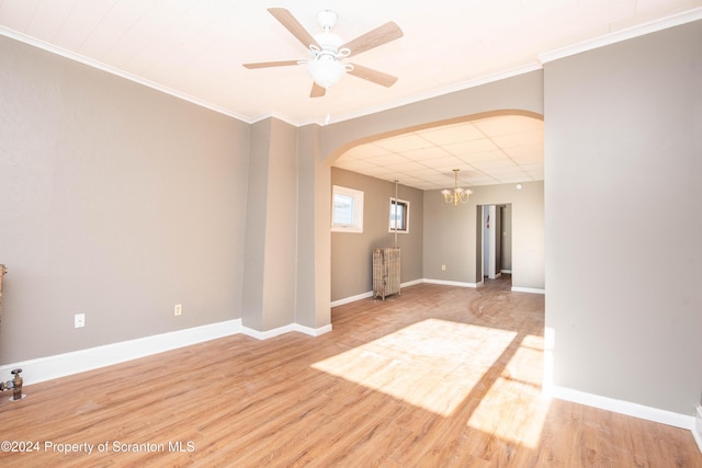 empty room with hardwood / wood-style floors, ceiling fan with notable chandelier, and ornamental molding