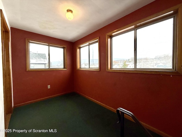 unfurnished room featuring plenty of natural light and carpet flooring