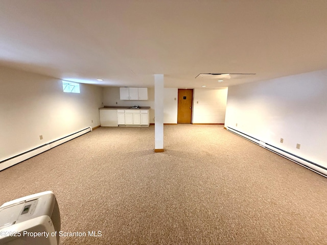 basement with sink, baseboard heating, and light carpet