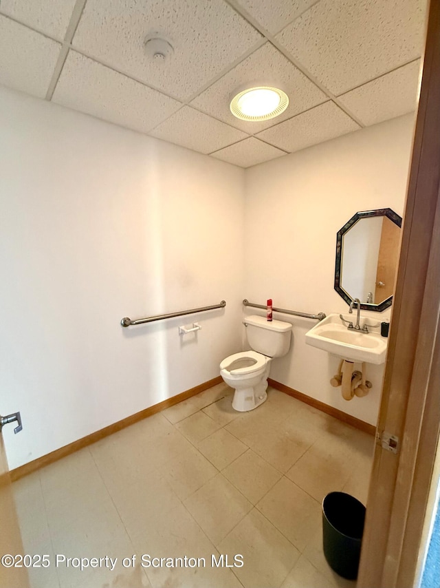 bathroom featuring sink, toilet, and a paneled ceiling